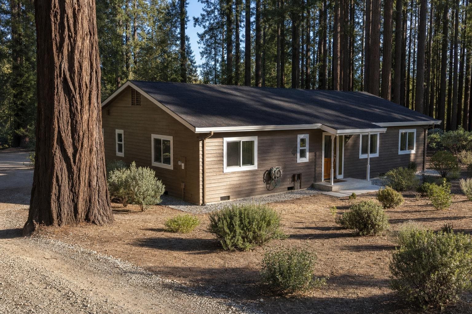 Defensible space landscaping around a Santa Cruz Mountains home with a gravel Zone 0 border and widely spaced drought-tolerant plantings